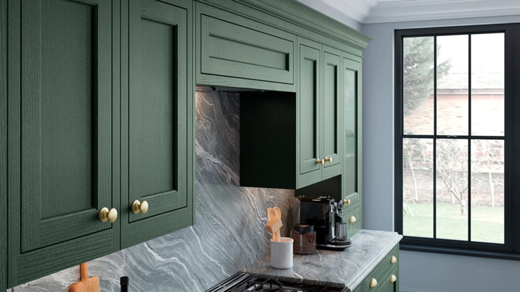 The Belgravia kitchen in deep forest green with gold handles and grey marble worktops.