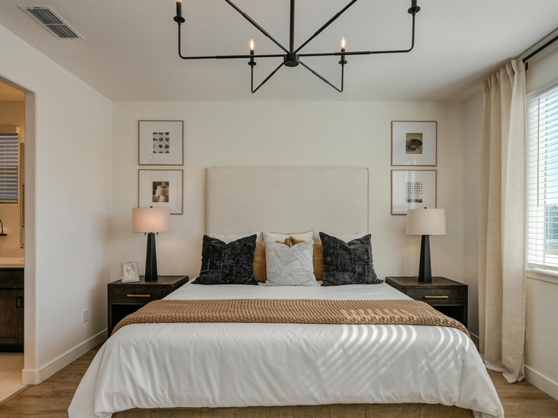 A neutral bedroom design featuring a double bed with accent pillows.